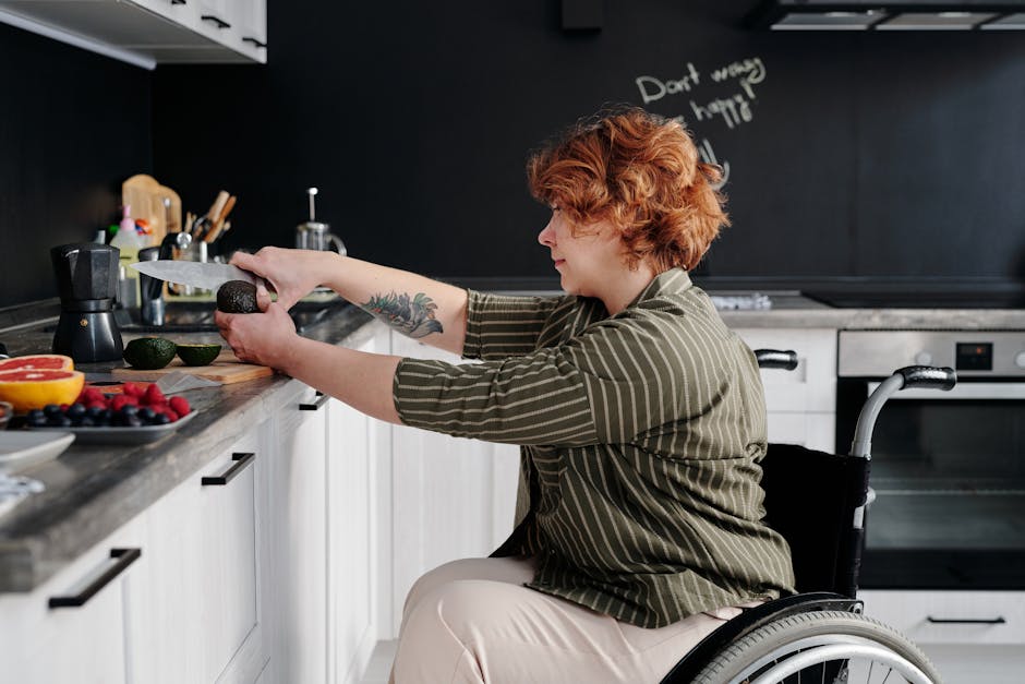A woman in a wheelchair cuts an avocado in a kitchen, emphasizing independence and healthy living.